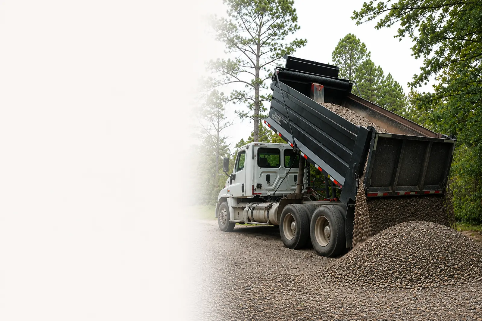 A Hello Gravel dump truck delivering a load of gravel to a Fort Worth driveway