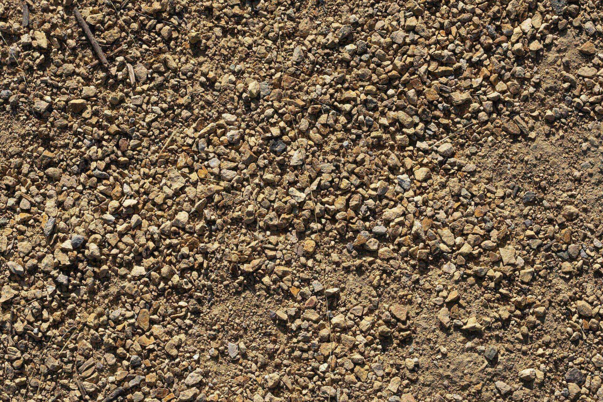 Cross-section view of pea gravel over sand base showing proper layering for walkway installation